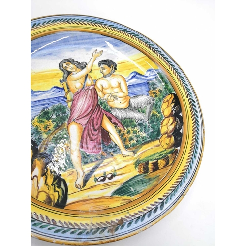 817 - An Italian Maiolica plate. Late 19th century, painted with Pan and Diana in a landscape, diameter 32... 