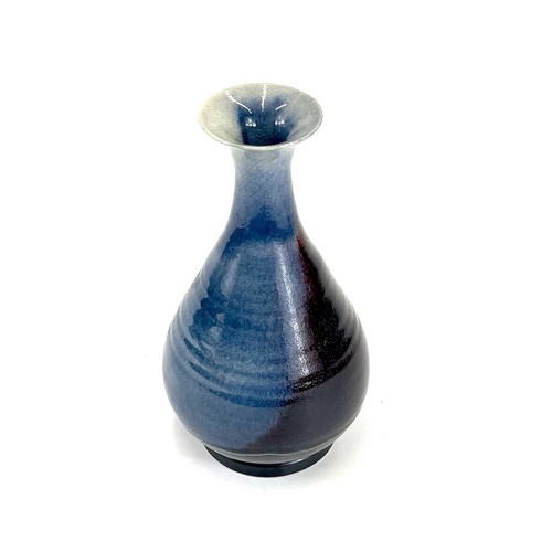 820 - Chris PRINDL A studio pottery bottle vase in a flambe glaze, signed to base, height 25.5cm.