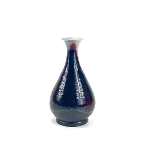 820 - Chris PRINDL A studio pottery bottle vase in a flambe glaze, signed to base, height 25.5cm.