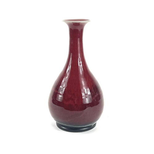 821 - Chris PRINDL A studio pottery bottle vase with an ox blood glaze, signed to base, height 26cm