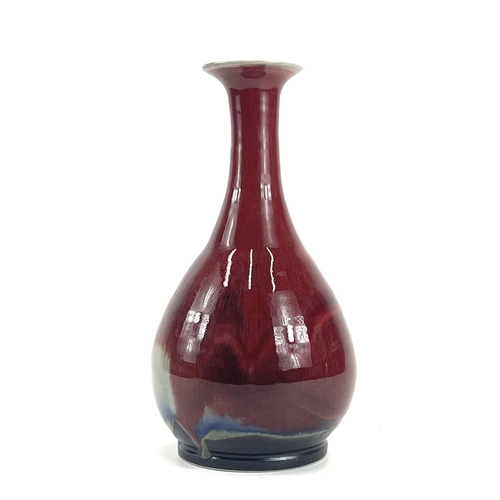 821 - Chris PRINDL A studio pottery bottle vase with an ox blood glaze, signed to base, height 26cm