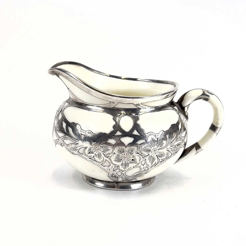 832 - A Royal Doulton white glazed silver overlaid three-piece tea service. The floral pierced and engrave... 