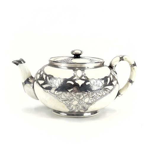 832 - A Royal Doulton white glazed silver overlaid three-piece tea service. The floral pierced and engrave... 