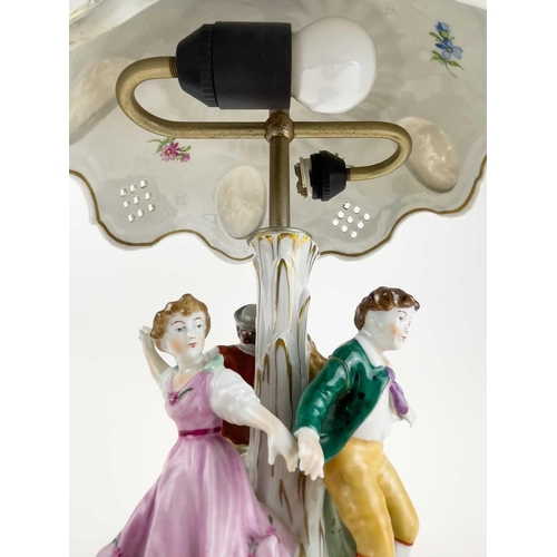 836 - A German porcelain figural flower encrusted table lamp and shade. Circa 1960s, the shade with lithop... 