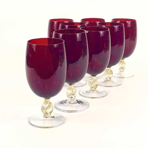 844 - A set of eight Venetian glass wine glasses. With ruby bowls and gilt flecked stems. Height 15cm.