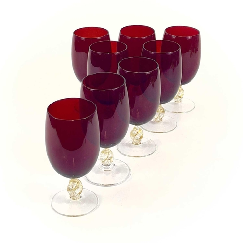 844 - A set of eight Venetian glass wine glasses. With ruby bowls and gilt flecked stems. Height 15cm.