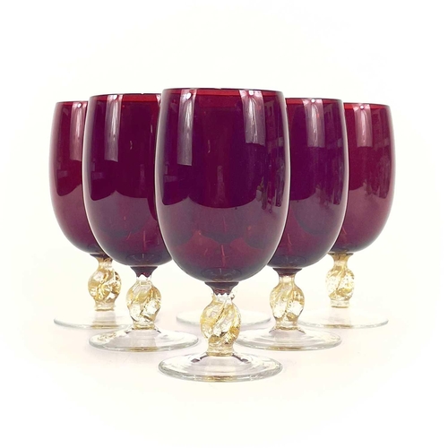 844 - A set of eight Venetian glass wine glasses. With ruby bowls and gilt flecked stems. Height 15cm.