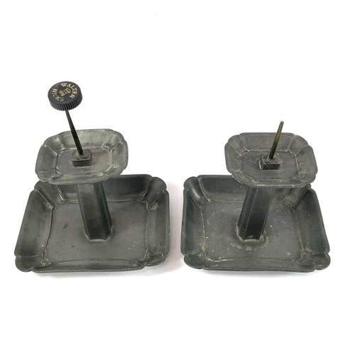 87 - A pair of Continental pewter pricket candlesticks. Late 19th century, with shaped rectangular bases,... 