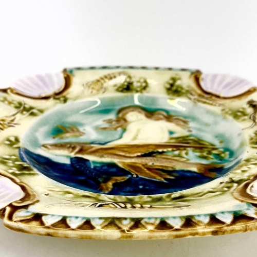 878 - A Majolica plate, French circa 1880. Relief decorated a mermaid and flying fish within a border of c... 