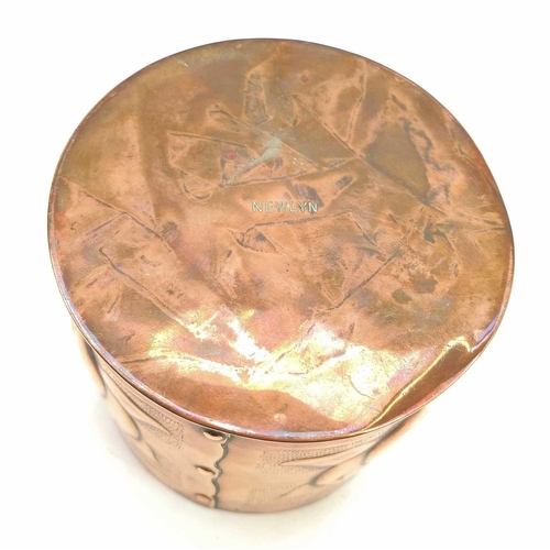 9 - A Newlyn copper cylindrical tea caddy and cover. Repousse decorated with medlars on a punched ground... 