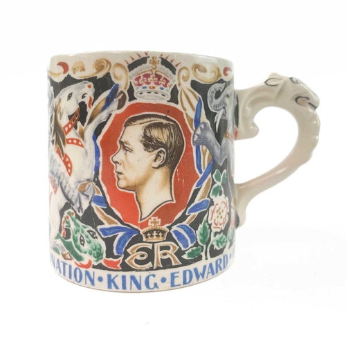 911 - A King George V coronation mug designed and modelled by Dame Laura Knight. Height 8cm together with ... 