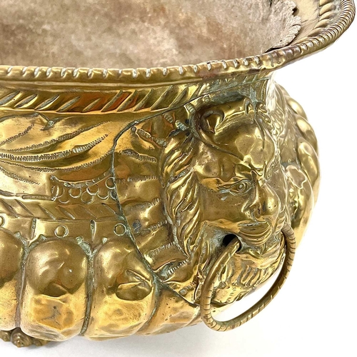 13 - A Dutch brass oval Jardiniere, 18th Century. With gadrooned and foliate embossed decoration, lion's ... 