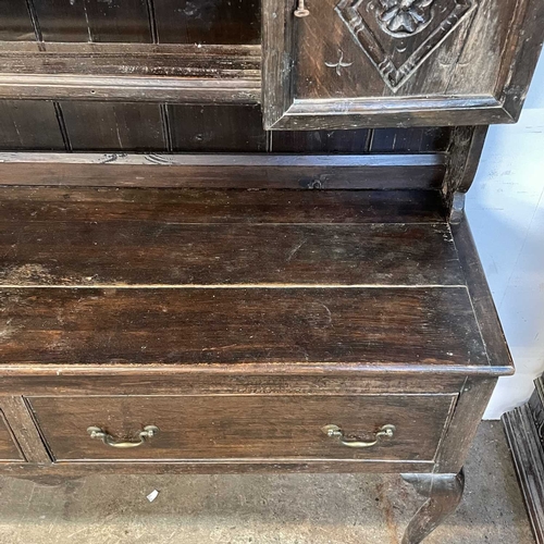 5 - A late Victorian oak dresser. The plate rack fitted two carved cupboard doors, the base with two dra... 