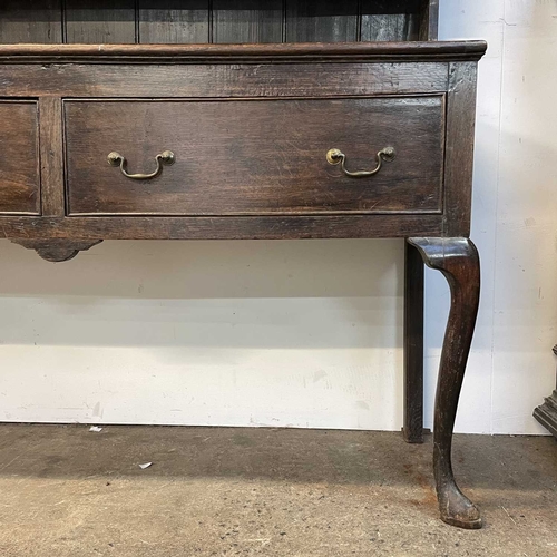 5 - A late Victorian oak dresser. The plate rack fitted two carved cupboard doors, the base with two dra... 