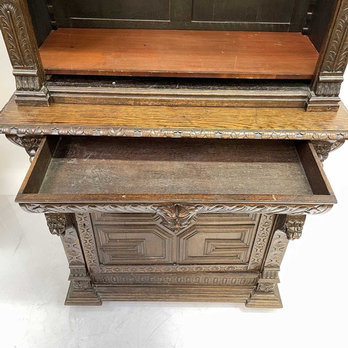 33 - A Victorian oak bookcase cabinet. The upper part with open adjustable shelves with lion mask ring mo... 