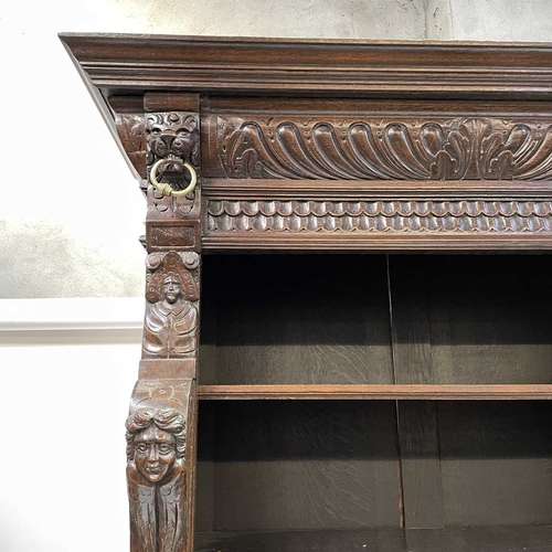 33 - A Victorian oak bookcase cabinet. The upper part with open adjustable shelves with lion mask ring mo... 