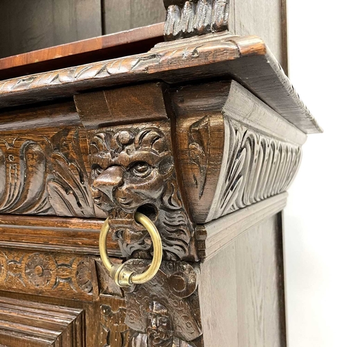 33 - A Victorian oak bookcase cabinet. The upper part with open adjustable shelves with lion mask ring mo... 