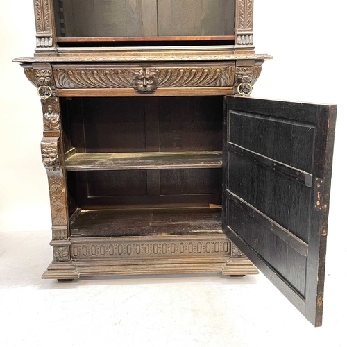 33 - A Victorian oak bookcase cabinet. The upper part with open adjustable shelves with lion mask ring mo... 