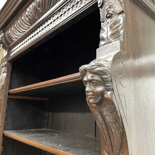 33 - A Victorian oak bookcase cabinet. The upper part with open adjustable shelves with lion mask ring mo... 