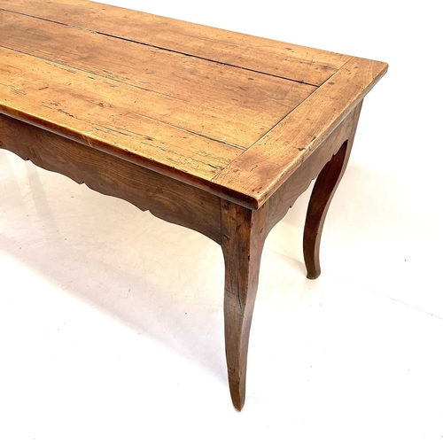 35 - A French fruitwood farmhouse kitchen table. Circa 1820, with cleated three plank top, shaped frieze ... 