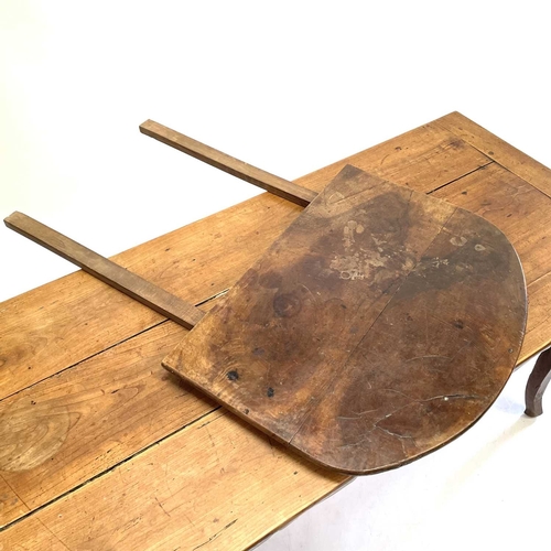 35 - A French fruitwood farmhouse kitchen table. Circa 1820, with cleated three plank top, shaped frieze ... 