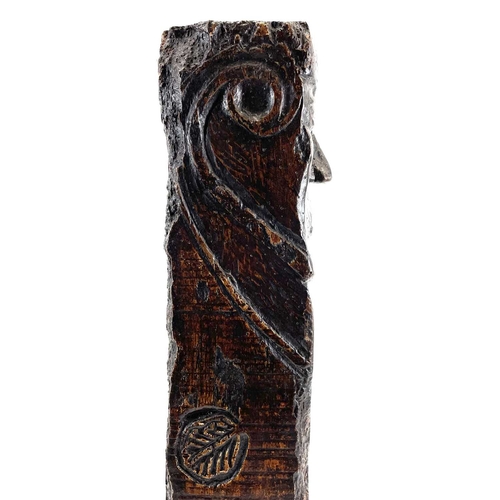 36 - A post medieval oak pillar. Carved with a bearded figure, an incised leaf to one side, height 63.5cm... 