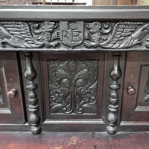 50 - An oak court cupboard, partly 17th century. The carved frieze with initials C.R.B above two doors fl... 