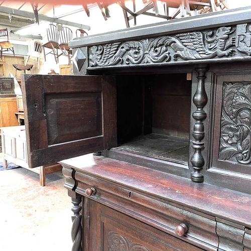 50 - An oak court cupboard, partly 17th century. The carved frieze with initials C.R.B above two doors fl... 