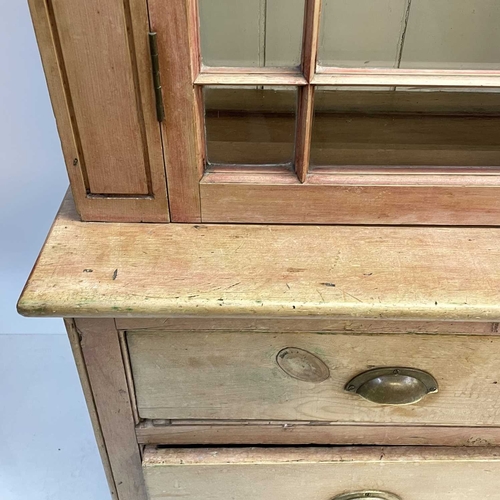 57 - A Victorian Cornish pine farmhouse kitchen dresser. The upper part with two glazed doors enclosing s... 