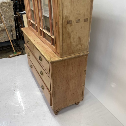 57 - A Victorian Cornish pine farmhouse kitchen dresser. The upper part with two glazed doors enclosing s... 