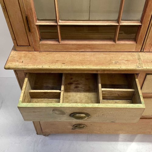 57 - A Victorian Cornish pine farmhouse kitchen dresser. The upper part with two glazed doors enclosing s... 