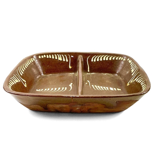 104 - A slipware two division earthenware pie dish. 19th century with stylised decoration, height 8cm widt... 