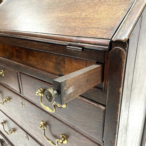 260 - A George II oak bureau, the fall front opening to reveal a fitted interior. Above two short and two ... 