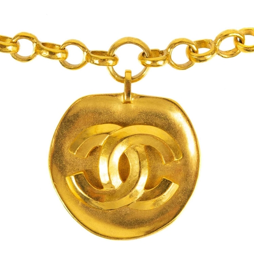 140 - A Chanel gold tone medallion pendant necklace. The CC cast pendant with matte finish, the necklace w... 