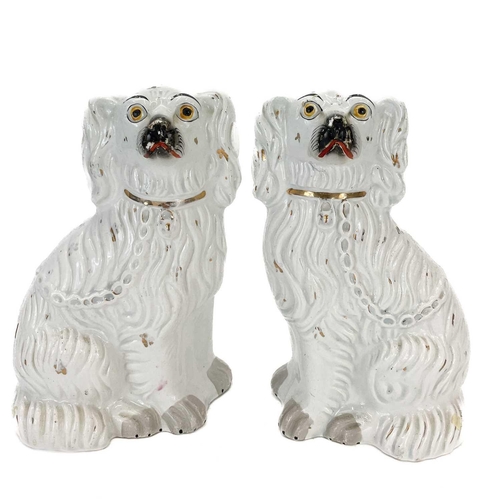 113 - A pair of Victorian Staffordshire figures of oversized spaniels. Seated beside diminutive figures wi... 