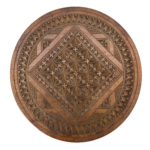 122 - A Swedish folk art fruitwood chip carved circular plaque. Diameter 23cm, together with a reconstitut... 