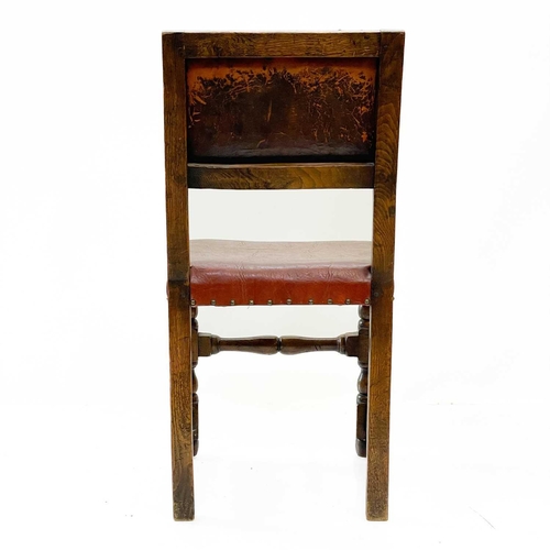 129 - A pair of oak and leather Cromwellian style chairs. With padded backs and seats on turned square sec... 