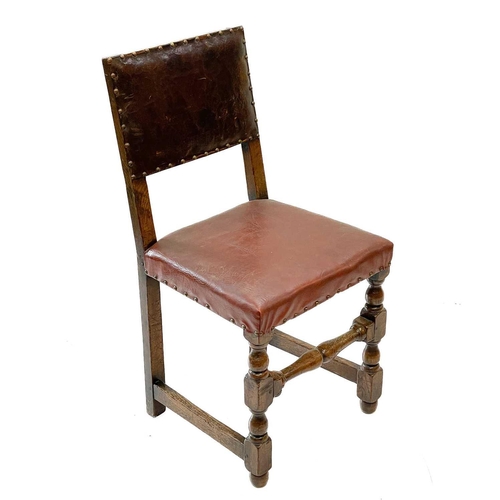 129 - A pair of oak and leather Cromwellian style chairs. With padded backs and seats on turned square sec... 