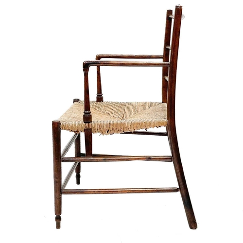 13 - A 19th century Sussex ash elbow chair. With adze carved ladder back over a rush seat on tapering spl... 