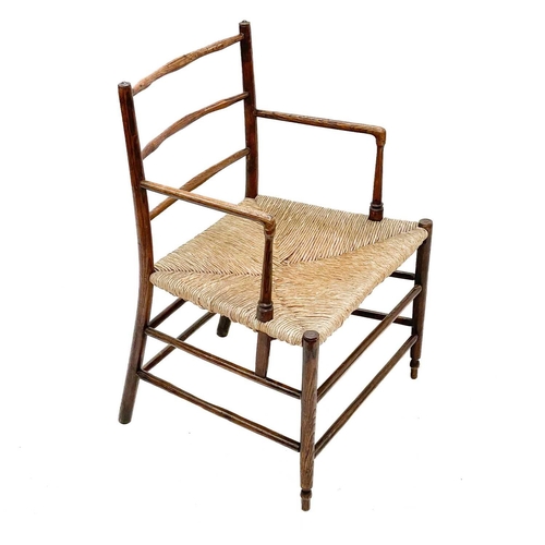 13 - A 19th century Sussex ash elbow chair. With adze carved ladder back over a rush seat on tapering spl... 