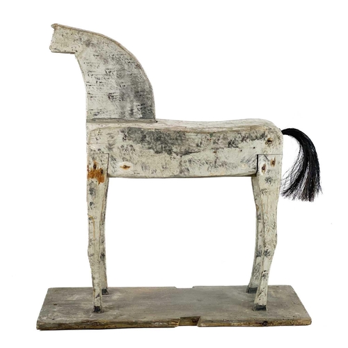 131 - A naive painted toy horse. Late 19th/early 20th century, raised on a plank base, height 55cm, width ... 