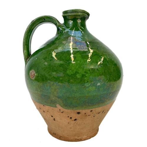 188 - A 19th century French pottery oil jug. With rich green glaze, height 24cm.Chip to rim, some wear and... 