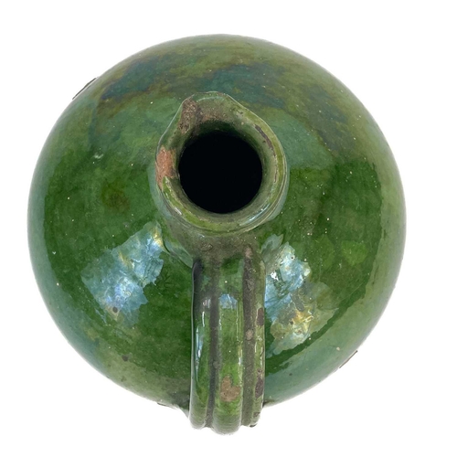 188 - A 19th century French pottery oil jug. With rich green glaze, height 24cm.Chip to rim, some wear and... 