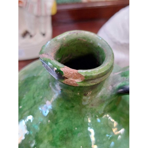 188 - A 19th century French pottery oil jug. With rich green glaze, height 24cm.Chip to rim, some wear and... 