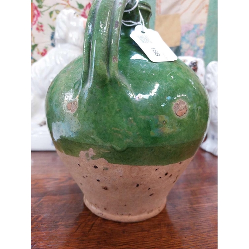 188 - A 19th century French pottery oil jug. With rich green glaze, height 24cm.Chip to rim, some wear and... 