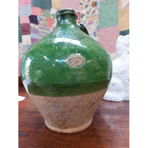 188 - A 19th century French pottery oil jug. With rich green glaze, height 24cm.Chip to rim, some wear and... 