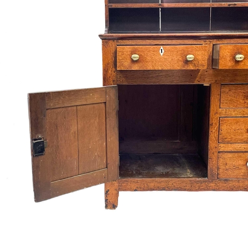 19 - An oak dresser and rack. Early 19th century, with a plain cornice above three shelves, the lower par... 