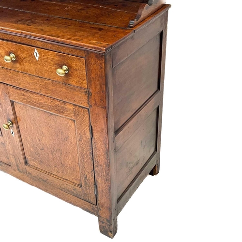 19 - An oak dresser and rack. Early 19th century, with a plain cornice above three shelves, the lower par... 