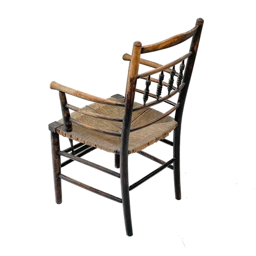 213 - A stained beech elbow chair. 19th century, with turned spindle and rail back, seagrass seat and turn... 