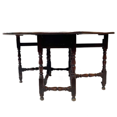 226 - An oak gateleg table. 17th/early 18th century, with an oval drop flap top and turned bobbin and squa... 